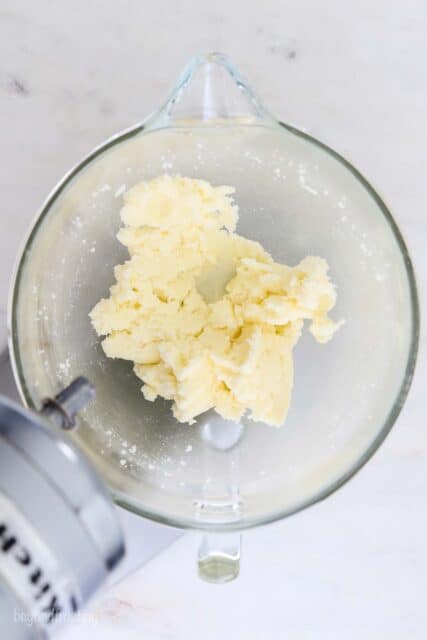 a glass mixing bowl with creamed butter and sugar