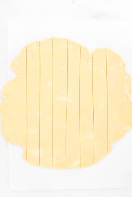 Pie crust dough rolled out into a disc and cut into strips