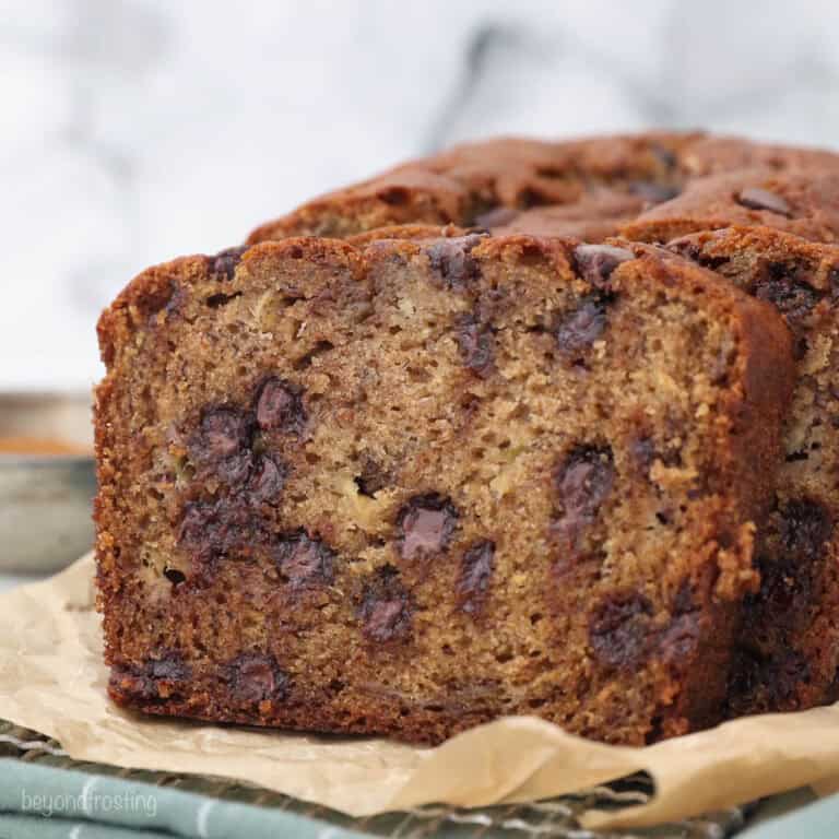 Sliced chocolate chip banana bread on a piece of brown parchment paper.