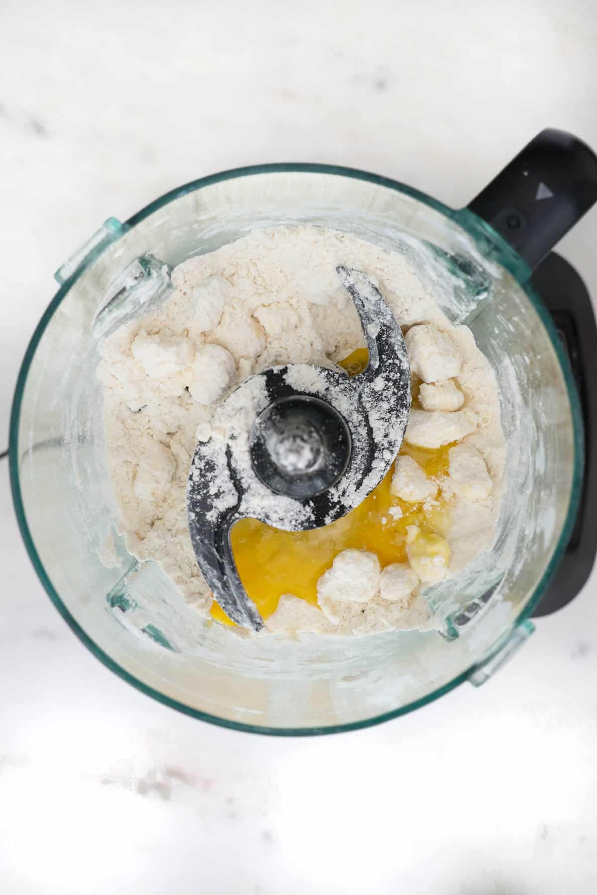 Flour, butter and an egg pulsed together inside of a food processor