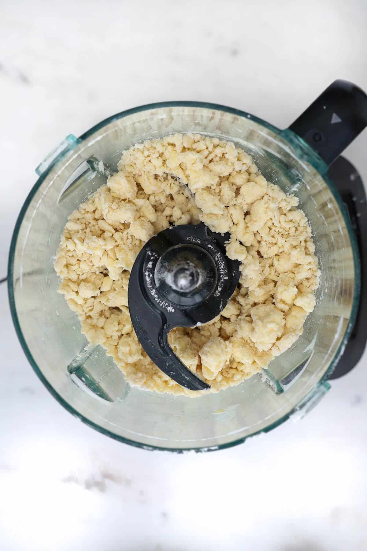 crumbly pie dough pulsed together in a food processor