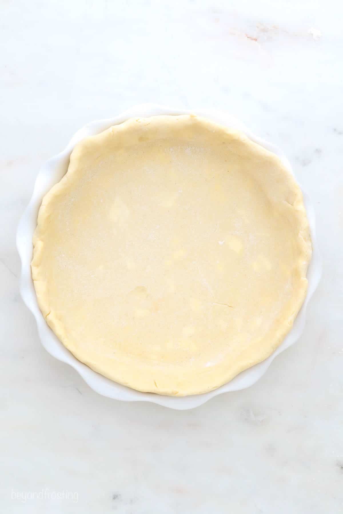 a gluten-free pie crust in a white pie dish