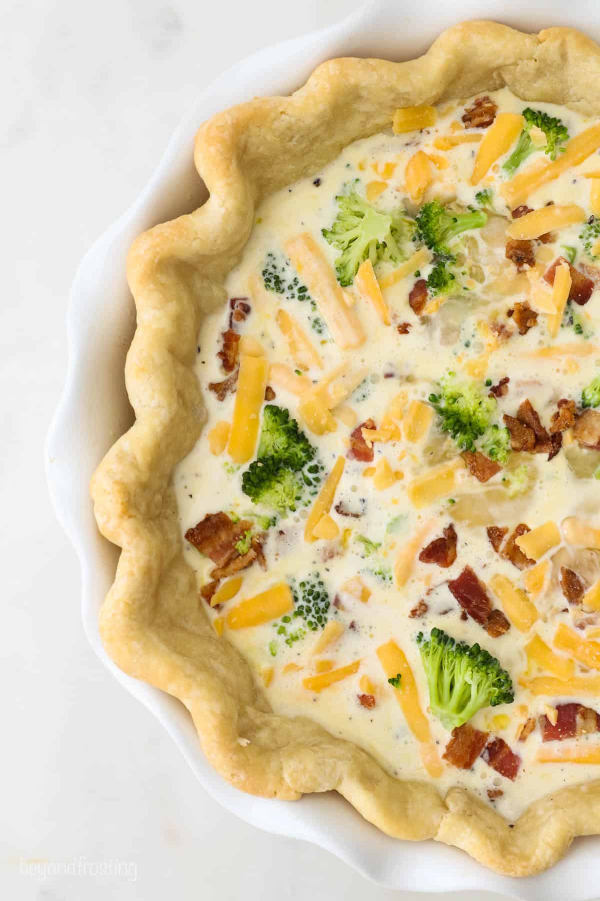 A pre-baked pie crust filled with cheese, broccoli, bacon and egg custard filling