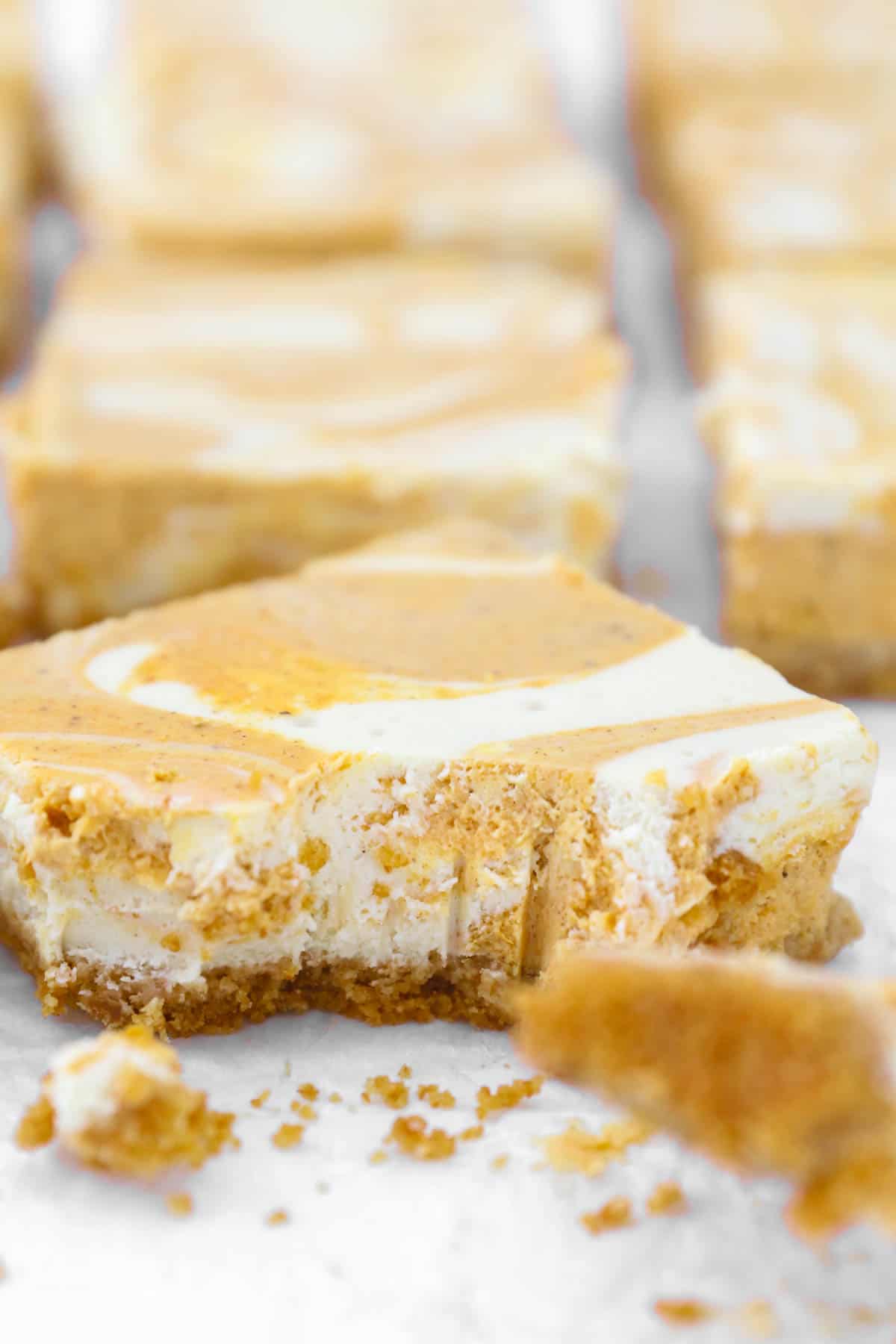 a close up of a pumpkin cheesecake bar with a bite missing