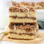 Twice slices of layered coffee cake on a piece of brown parchment paper and gold forks