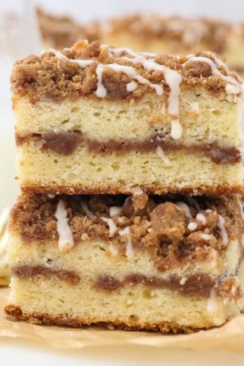 Twice slices of layered coffee cake on a piece of brown parchment paper and gold forks