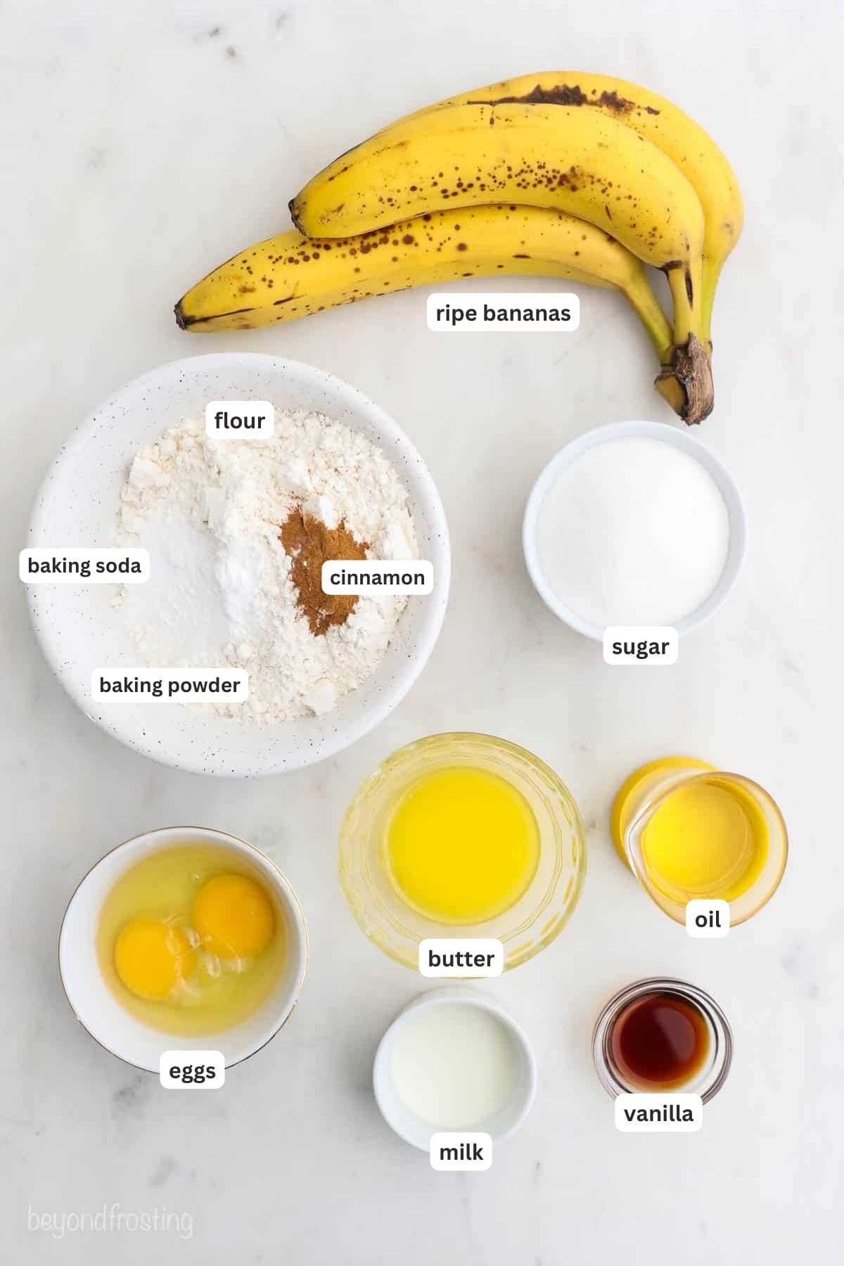 Ingredients for banana bread on a marble counter.