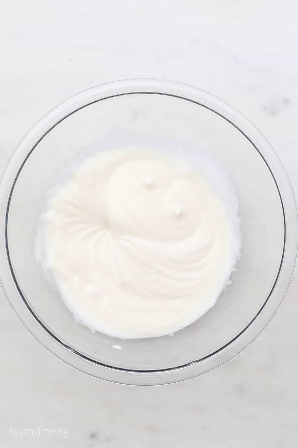 A mixture of egg whites, salt and cream of tartar beaten to soft peaks in a glass bowl