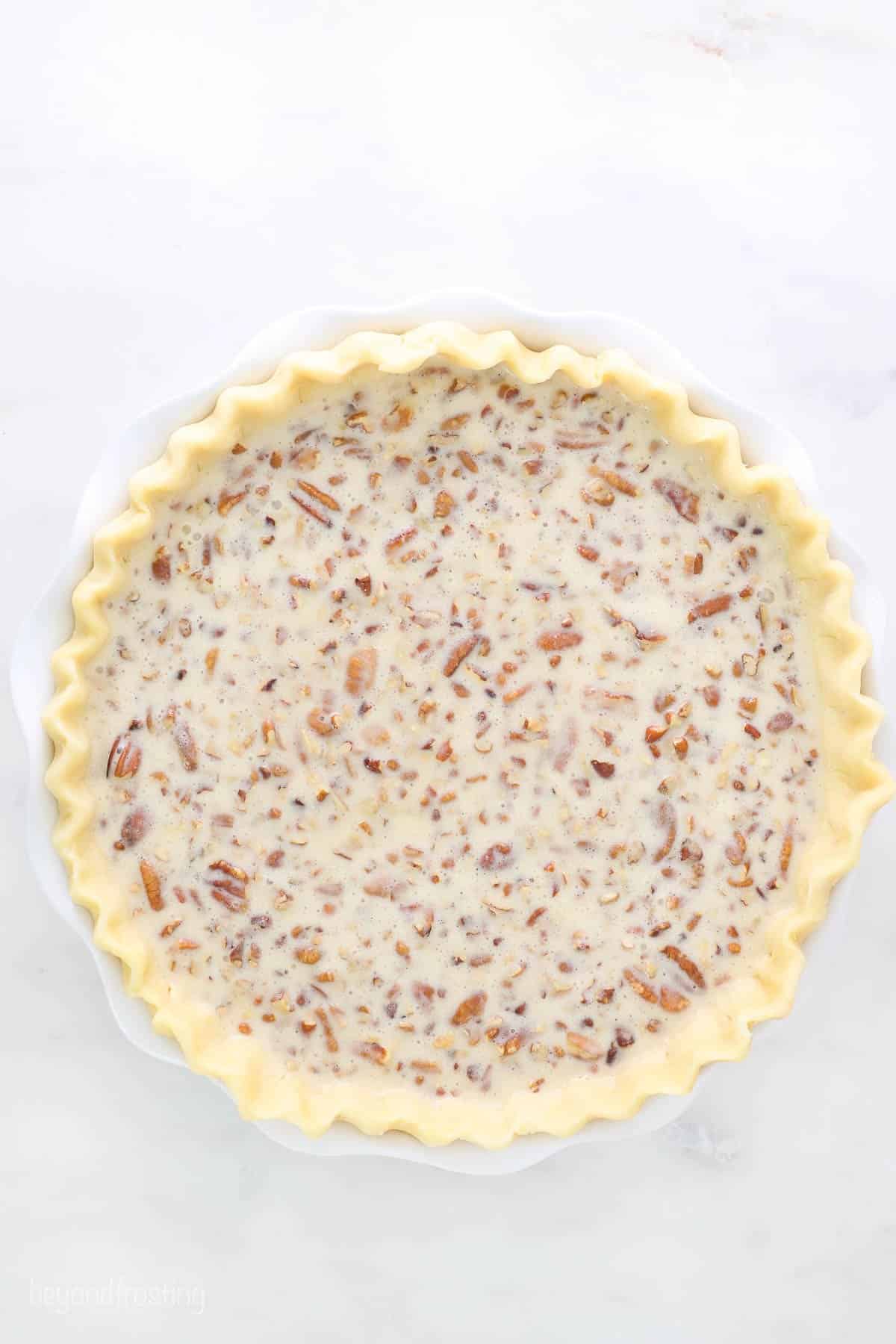 An unbaked pie crust filled with Kahlua pecan pie filling