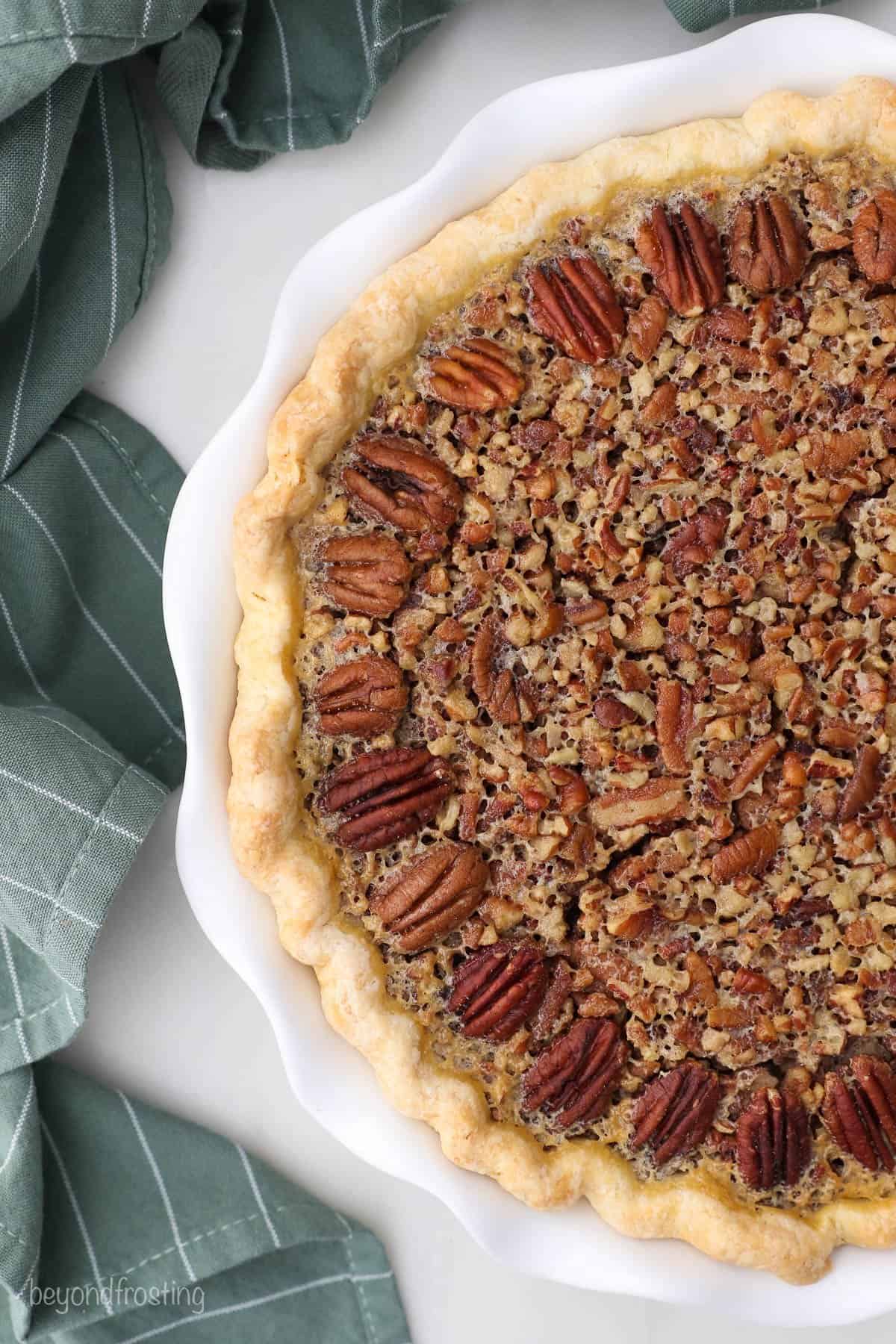 A bird's-eye view of half of a Kahlua pecan pie in a white pie dish
