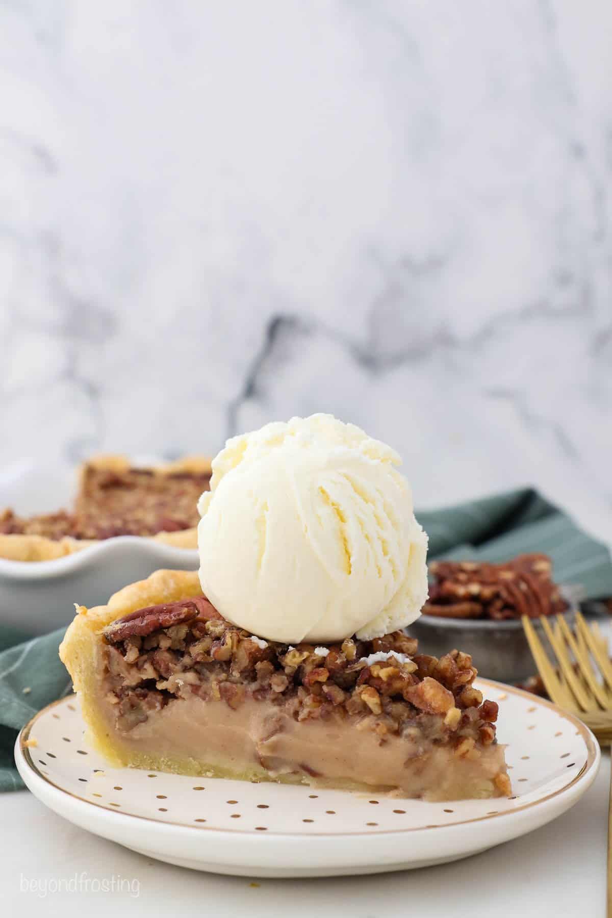 A slice of homemade pecan pie with a large scoop of ice cream on top