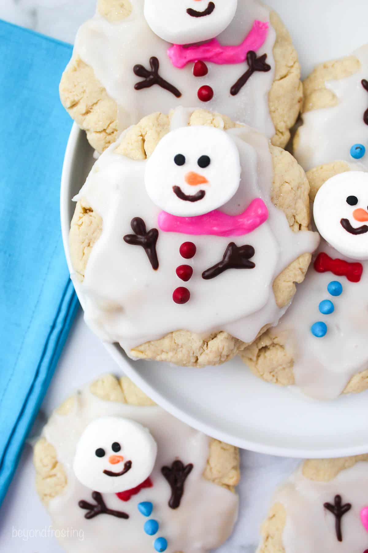 overhead of melted snowman cookies on a white plate