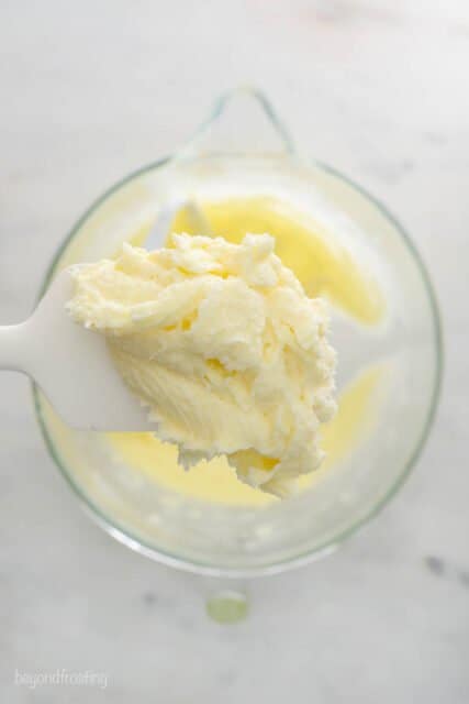 A scoop of creamed butter and sugar being displayed on a dessert spatula over the remaining mixture