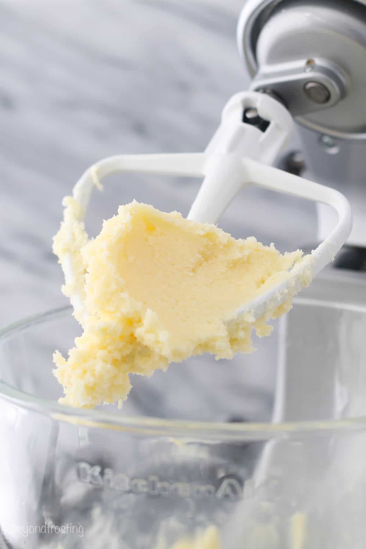 a stand mixer beater blade with creamed butter and sugar