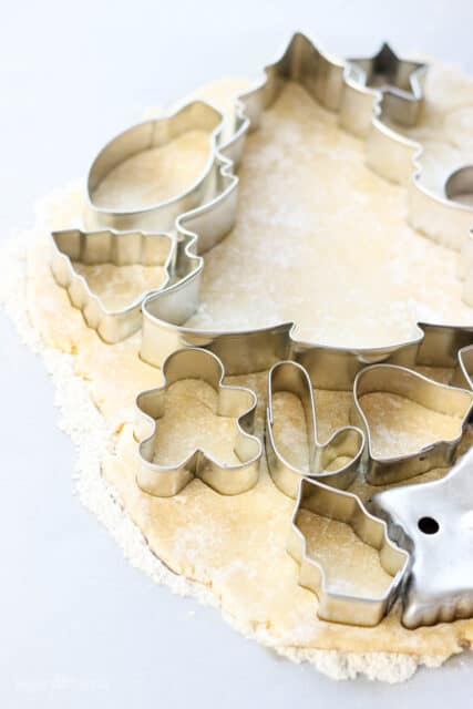 Cookie cutters laid out on a piece of rolled sugar cookie dough