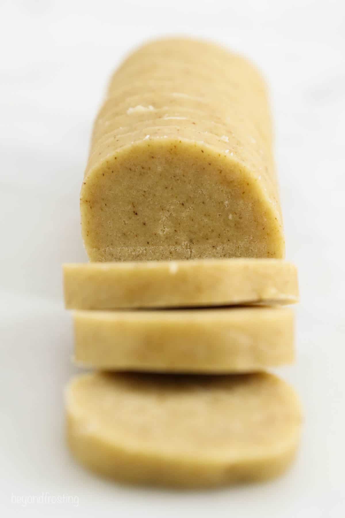 side view of a roll of cookie dough being sliced