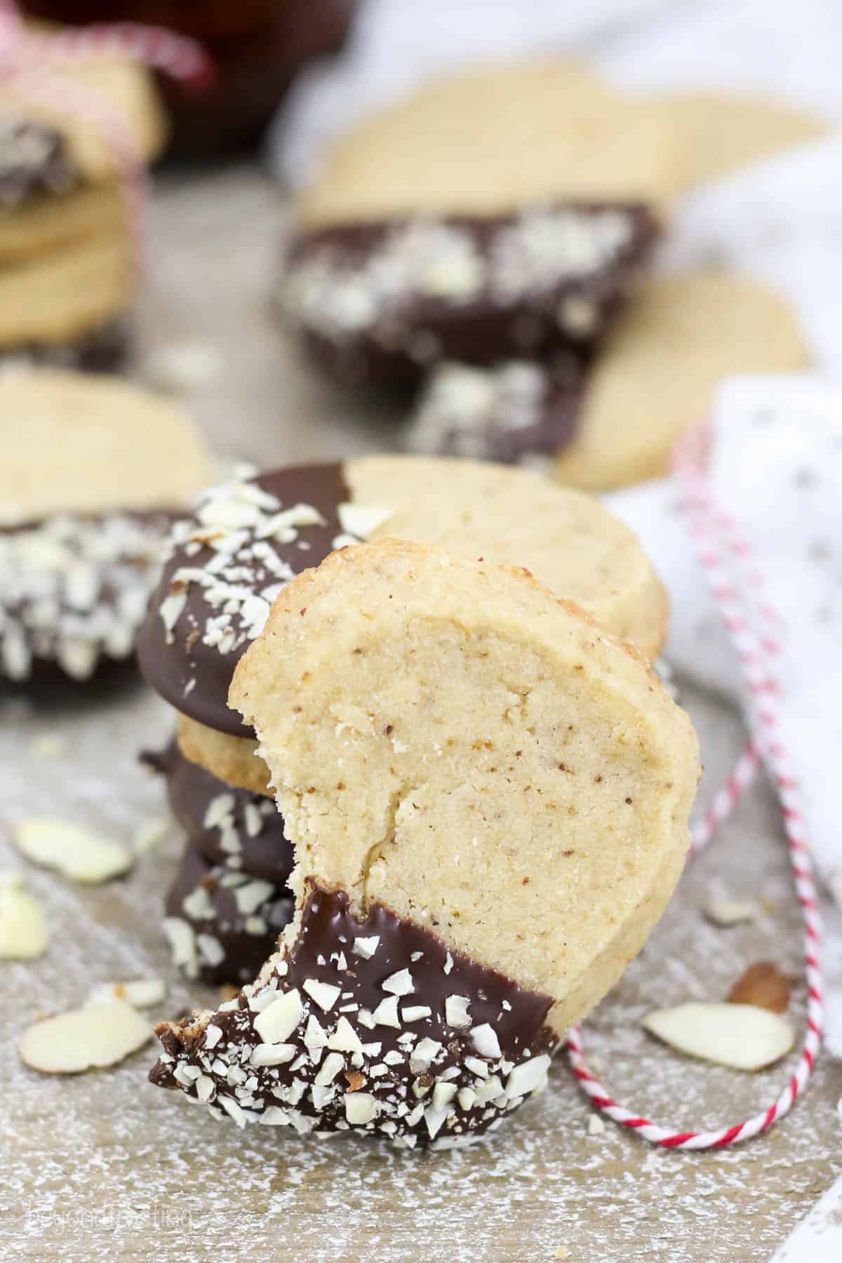 shortbread cookie with a bite taken out leaning on a stack of cookies