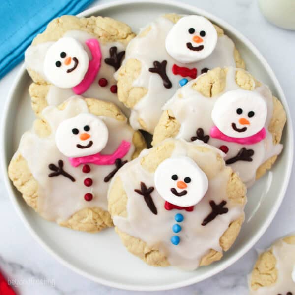 Overhead of melted snowman cookies on a plate with a blue napkin