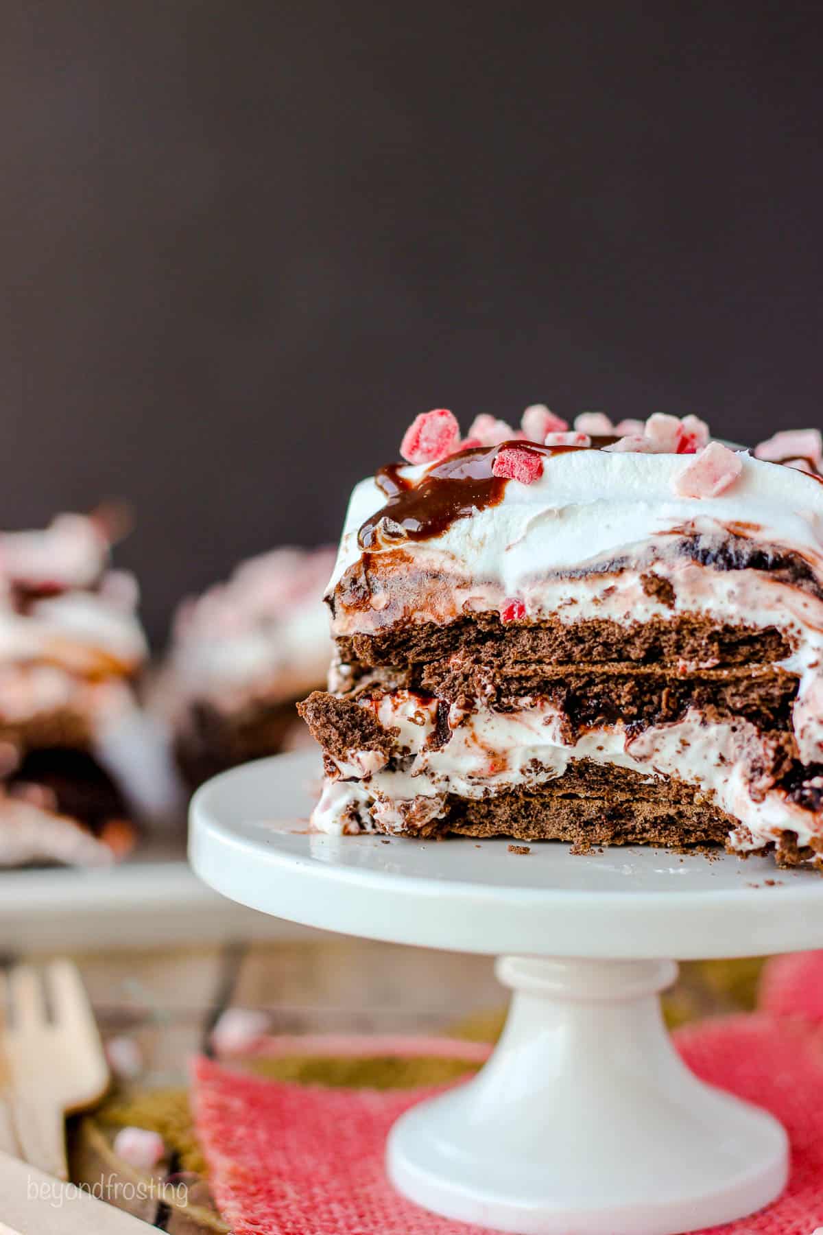 side view of a slice of chocolate peppermint lasagna on a white tray