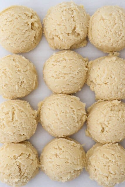 sugar cookie dough balls lined on a baking sheet