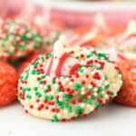 closeup of sugar cookie topped with peppermint kiss and coated in sprinkles