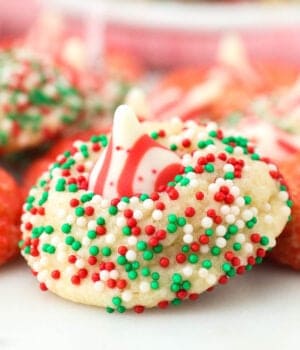 closeup of sugar cookie topped with peppermint kiss and coated in sprinkles