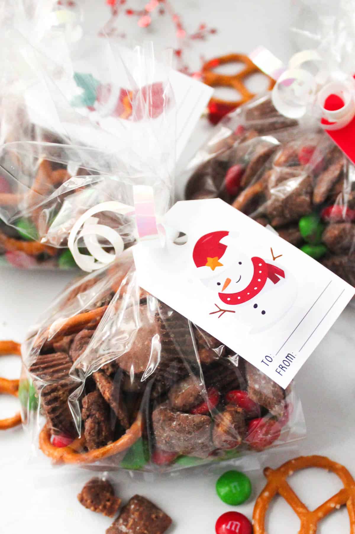 clear plastic bag filled with Christmas snack mix, tied with a ribbon and gift tag