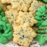 Green and off-white spritz cookies piled high onto a large serving plate