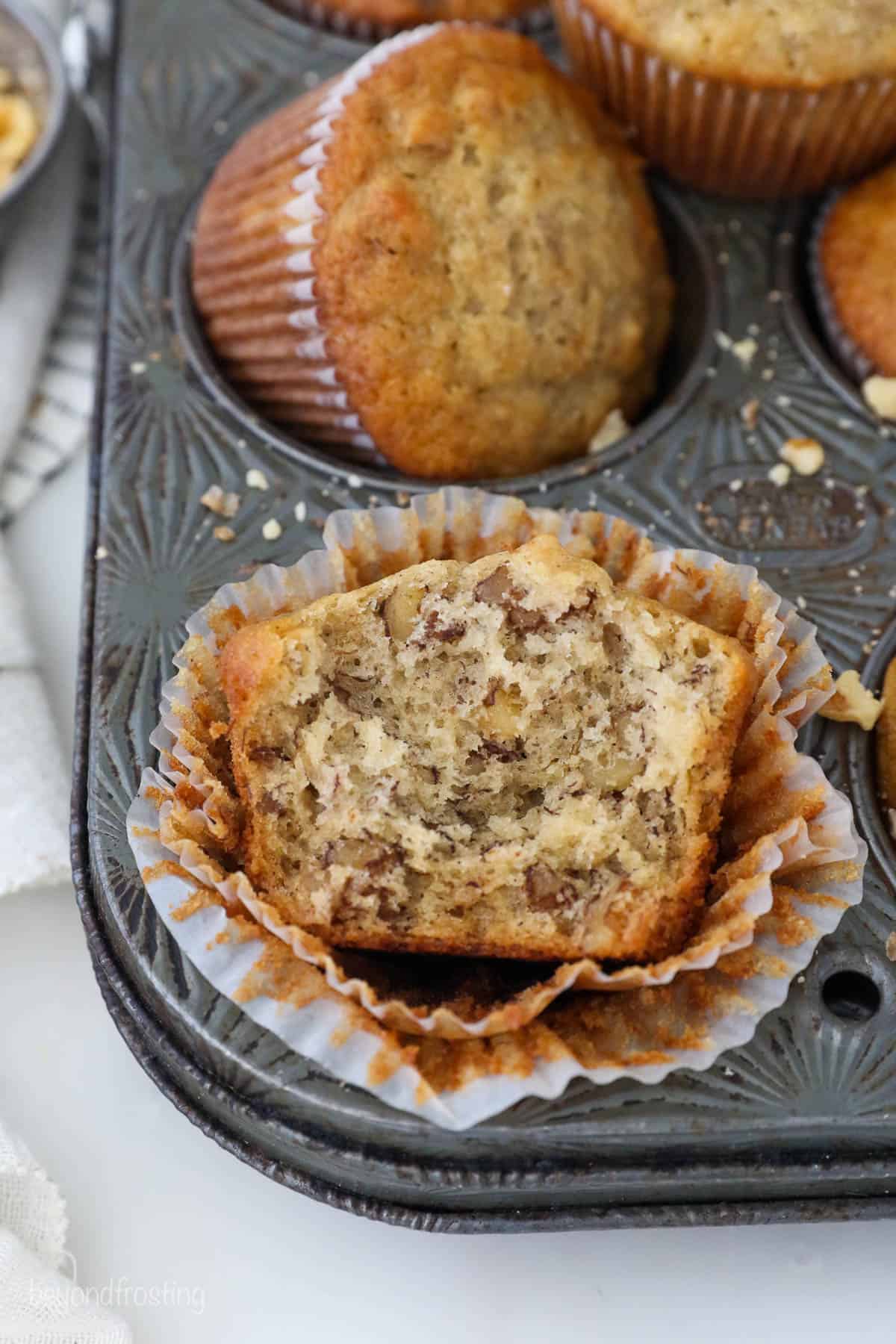 A half-eaten muffin sitting on top of two opened liners