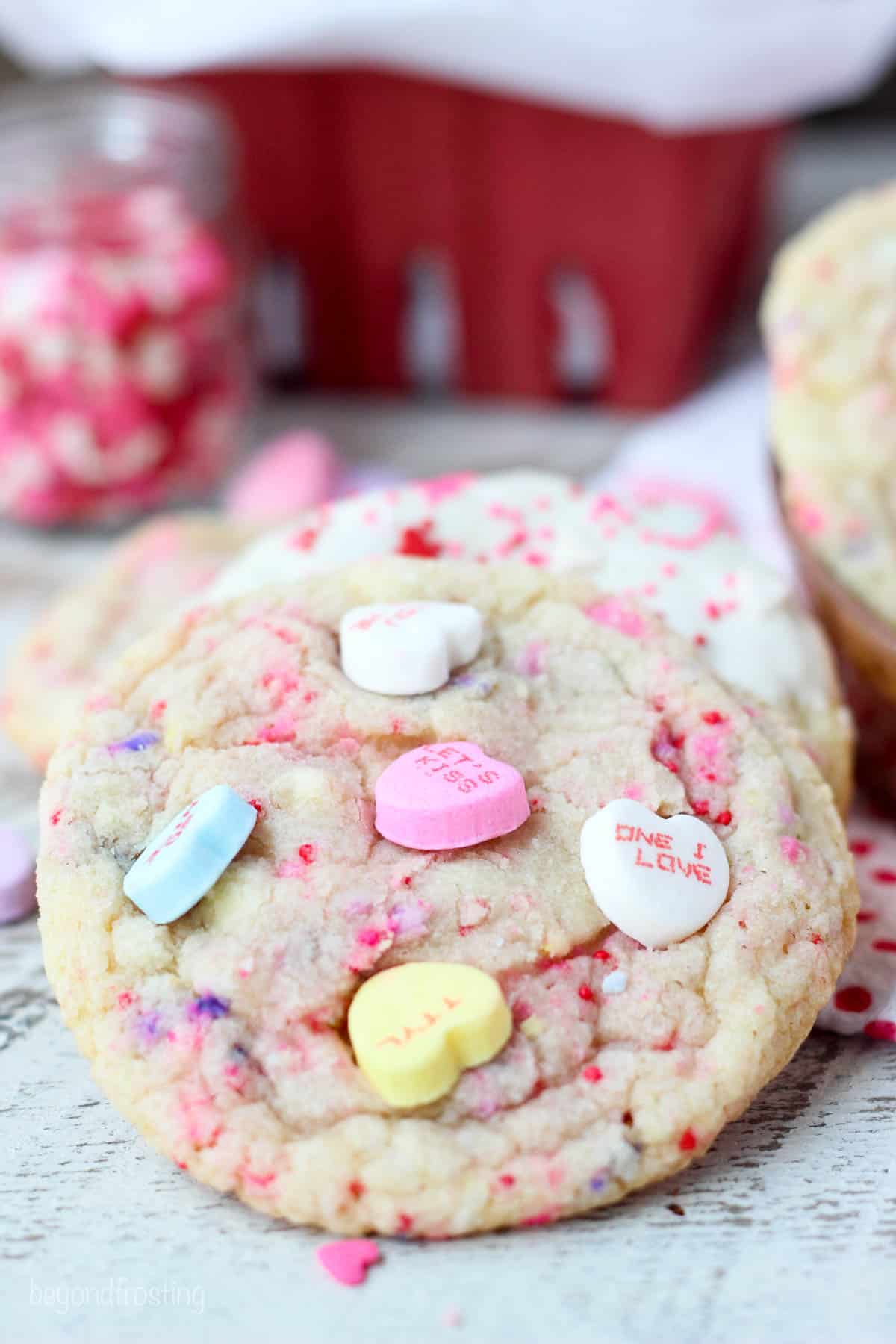 side view of a conversation heart cookie leaning on another cookie