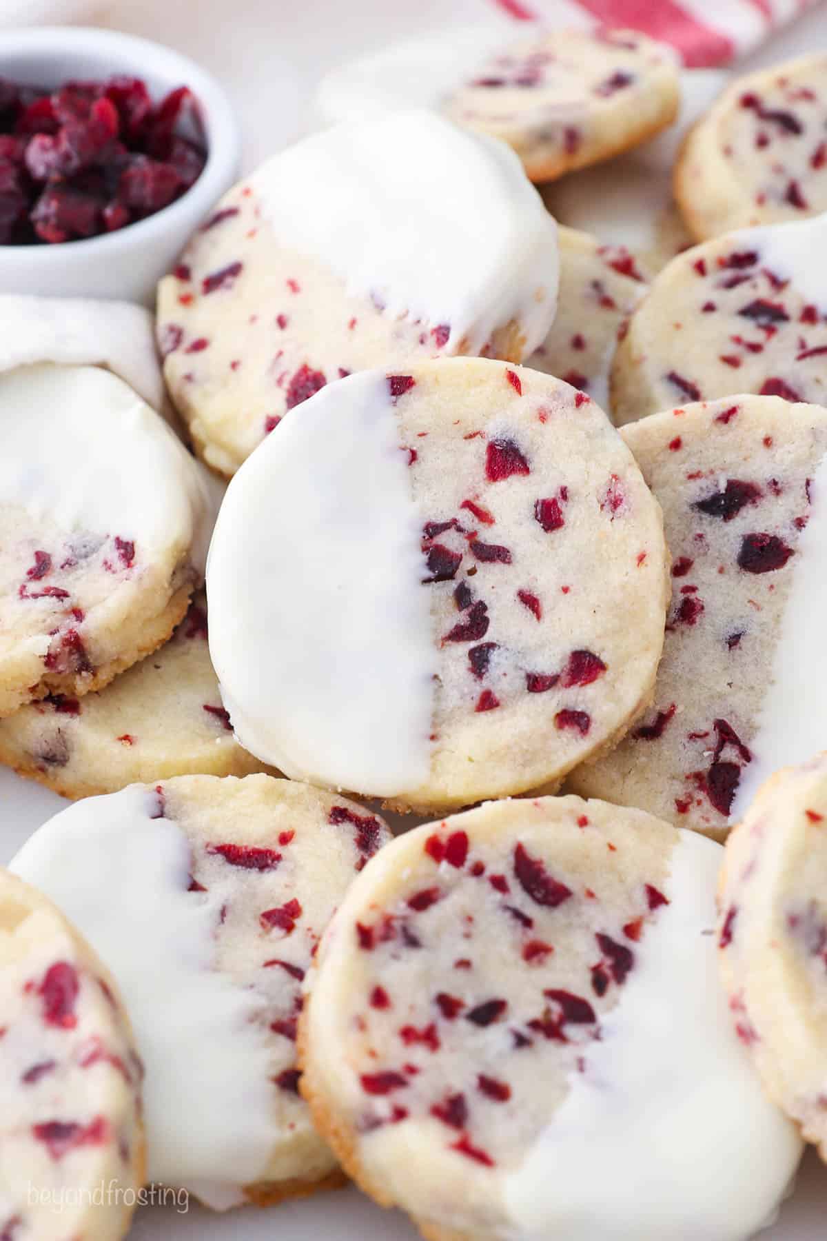 Stacked cranberry shortbread cookies dipped in white chocolate