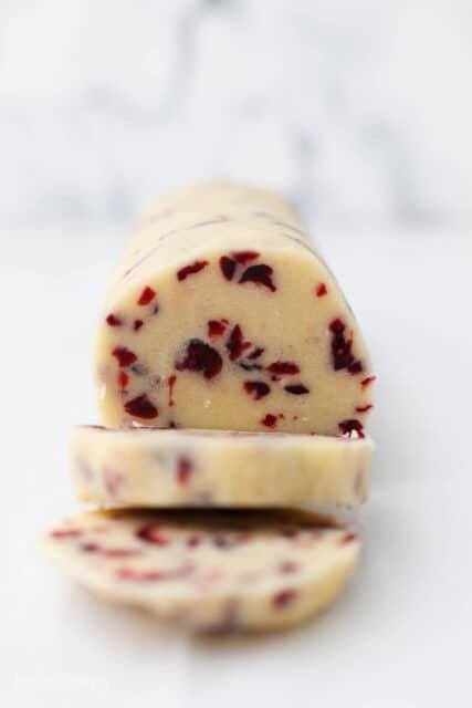 A sliced roll of cranberry shortbread cookies