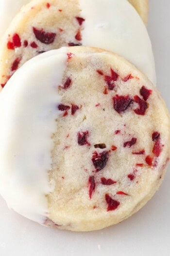 A close up of a white chocolate dipped cranberry shortbread cookie