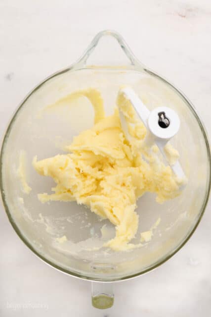 a glass mixing bowl and beater blade with creamed butter and sugar