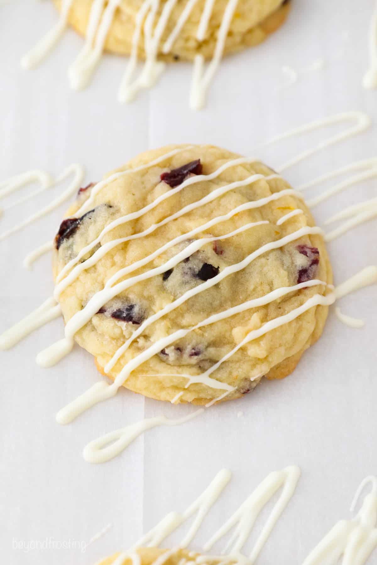 a white piece of parchment paper with a cookie and white chocolate drizzle