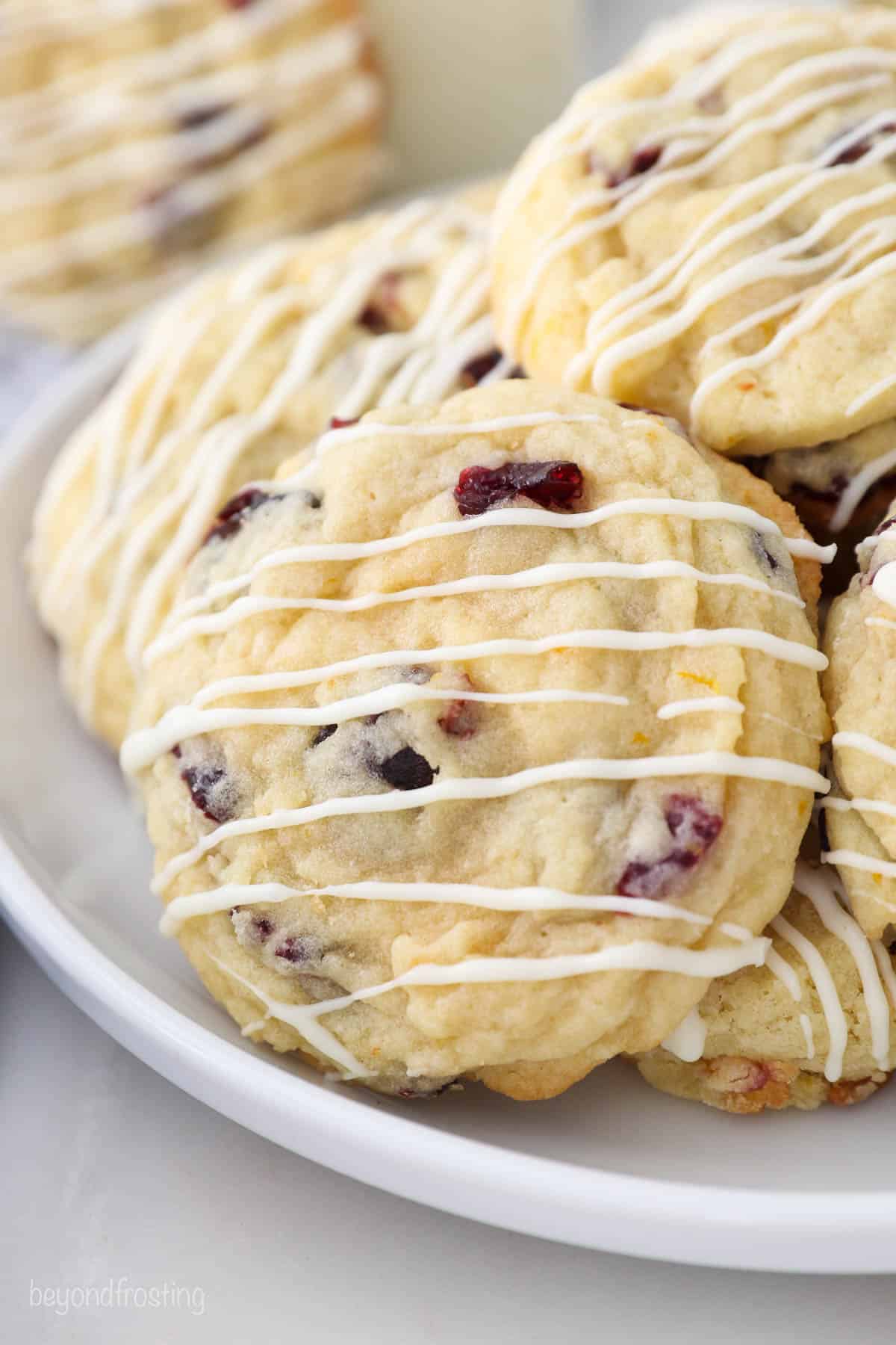 A white plate with stacked cranberry orange cookies