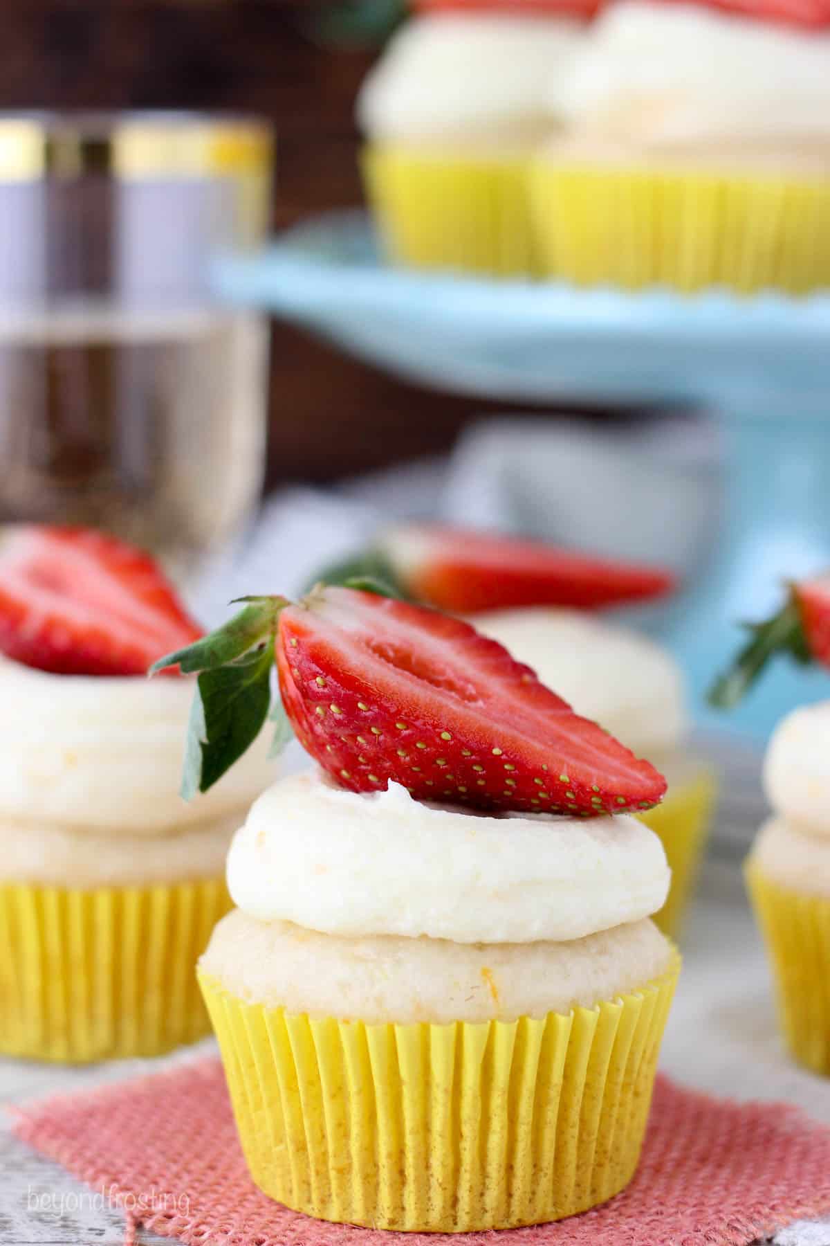 side view of champagne cupcakes topped with sliced strawberry