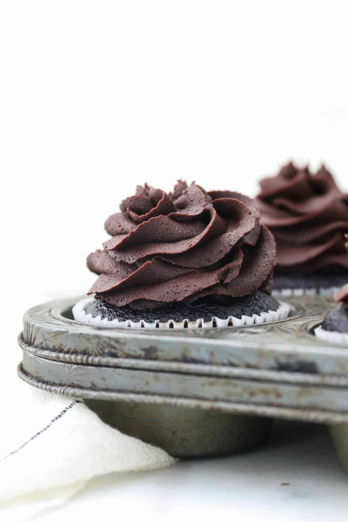 a vintage cupcake pan with a frosted chocolate cupcake