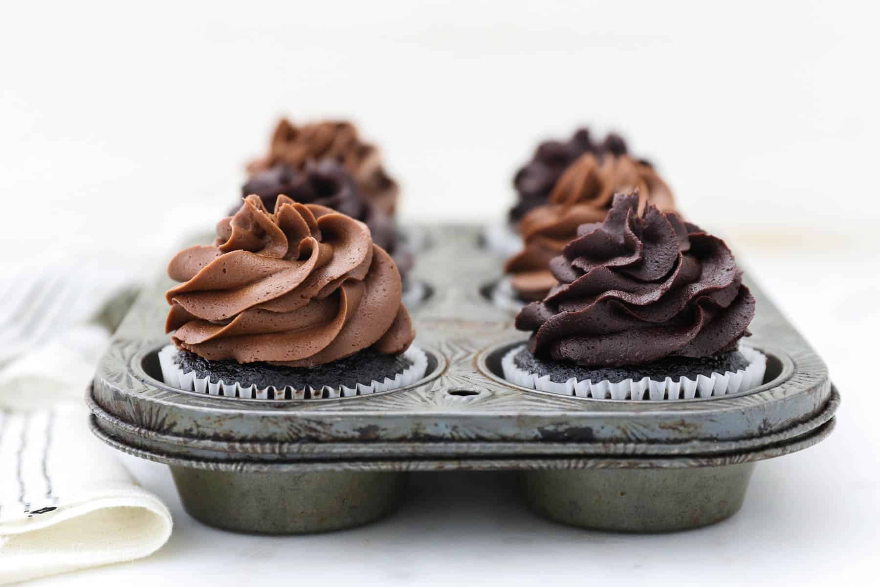 A vintage cupcake tray with frosted chocolate cupcakes