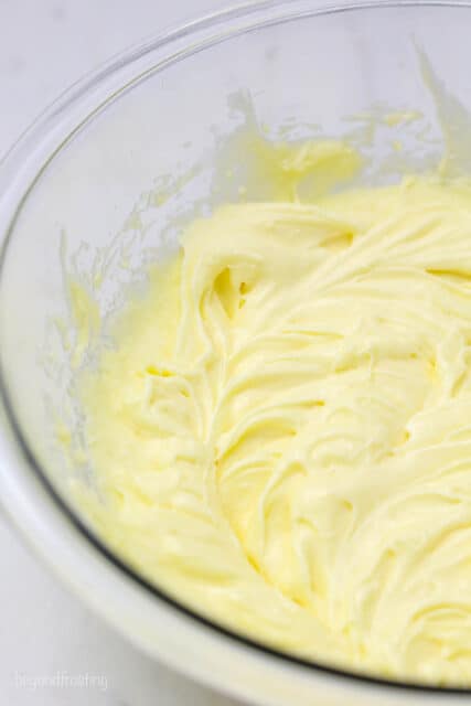 A cropped image of a glass bowl with whipped butter, sugar and eggs