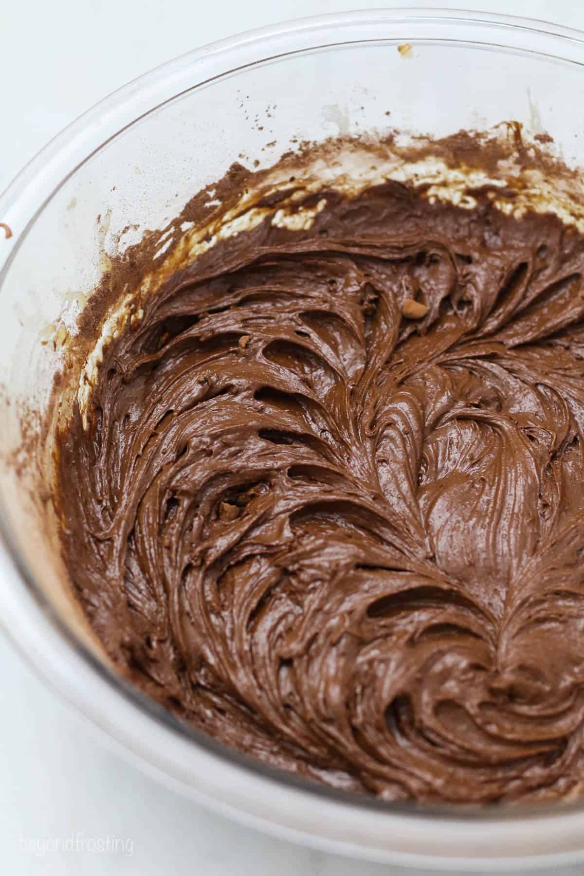 A glass mixing bowl with brownie batter