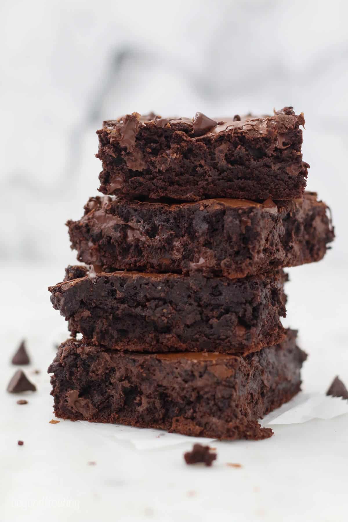 A stack of 4 thick fudgy brownies with melted chocolate chips