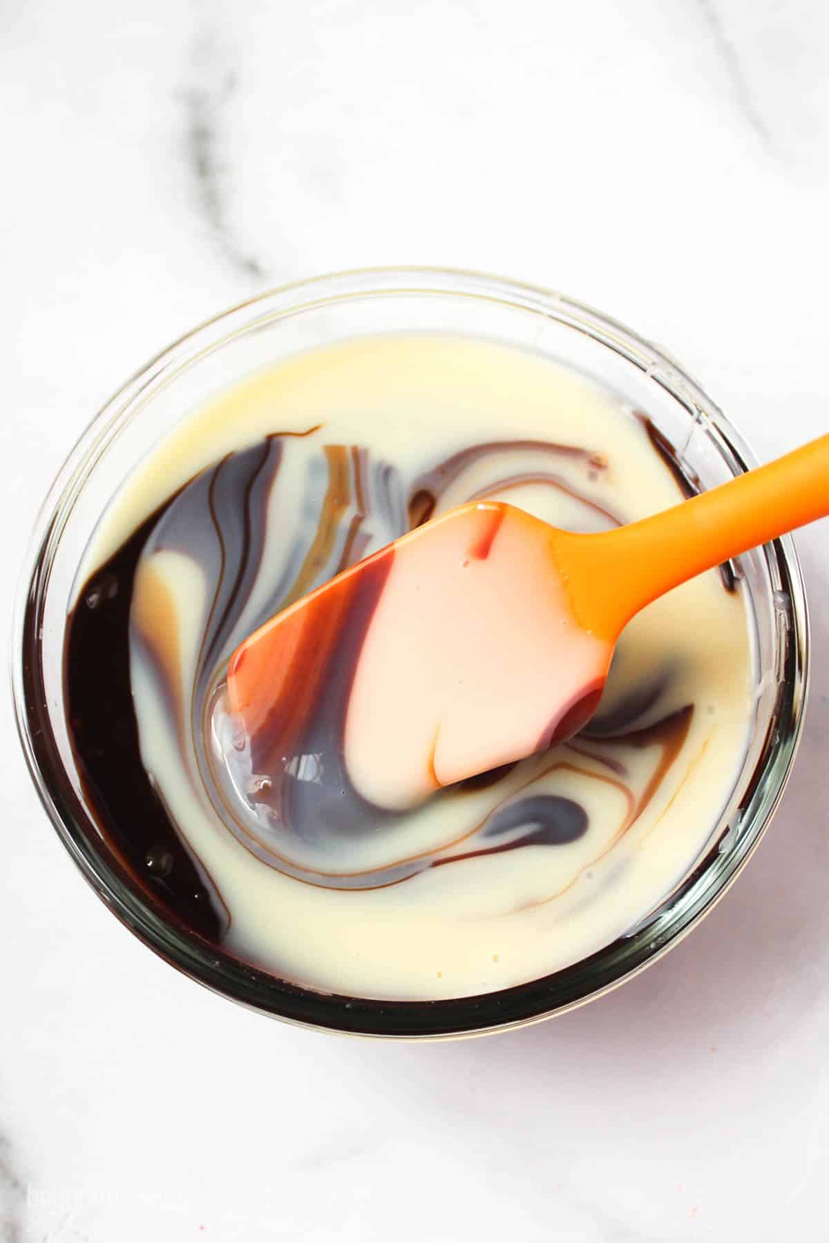 hot fudge sauce and sweetened condensed milk swirled together in a mixing bowl
