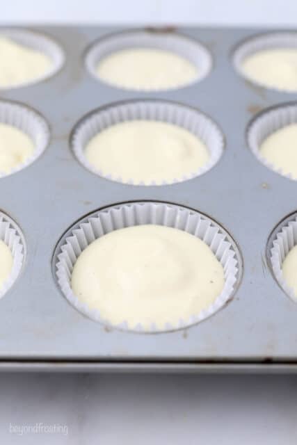 a cupcake pan with mini cheesecake batters