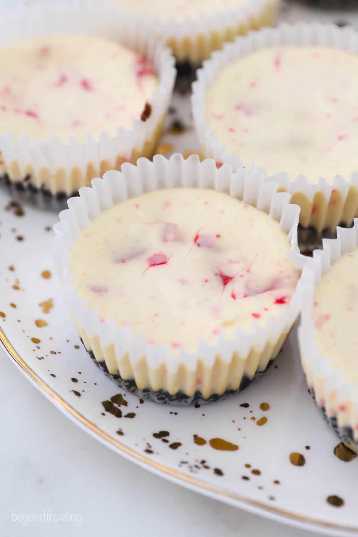 baked peppermint cheesecakes on a gold polka dot plate