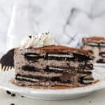 A white plate with a mousse cake layered with Oreos