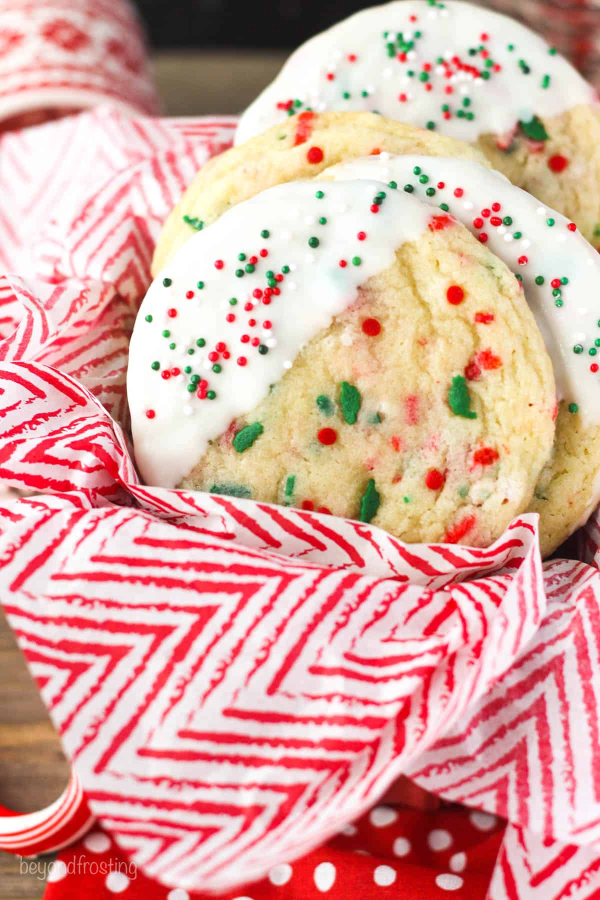 red and white tissue paper and white chocolate dipped sugar cookies with sprinkles
