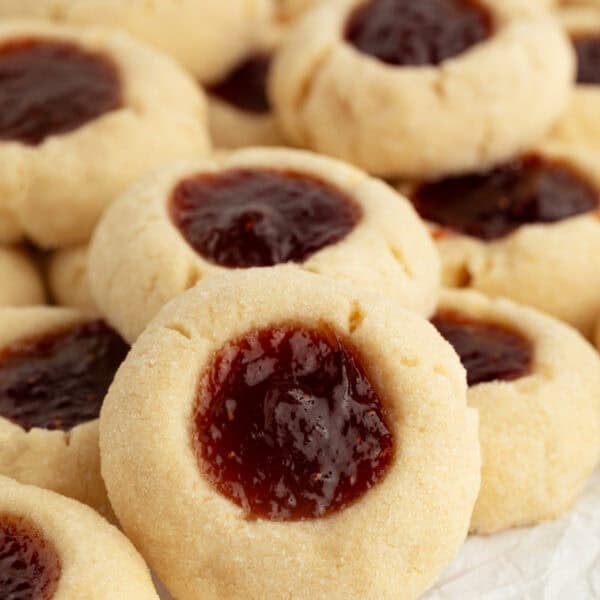 Assorted jam-filled thumbprint cookies piled on a countertop.