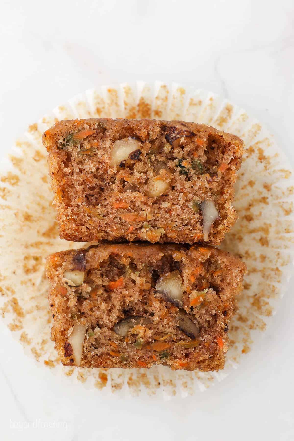 A carrot cake cupcake cut in half to reveal its moist and tender interior