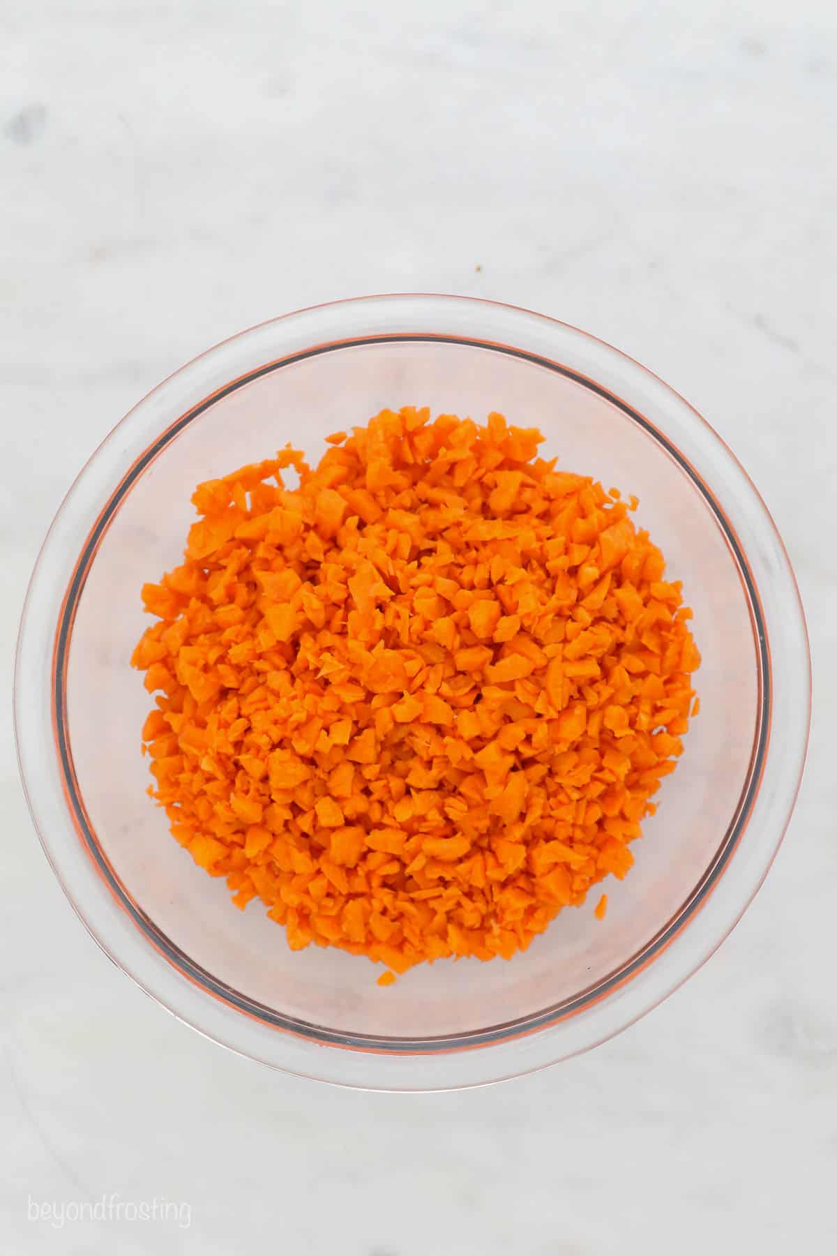 a glass bowl with finley chopped carrots